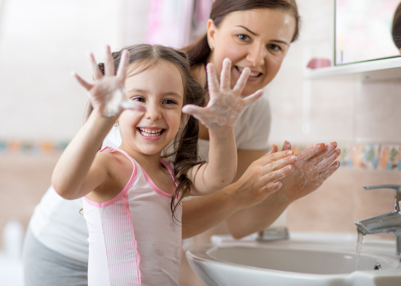Kid washing hands and showing soapy palms